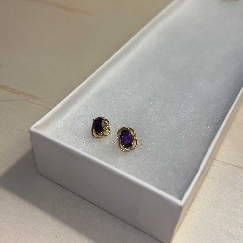 Gold colored earrings with purple jewels